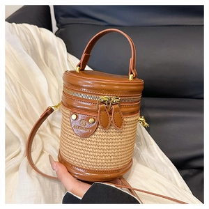 Dettaglio di una borsa a cilindro vintage con trama intrecciata beige e pelle marrone