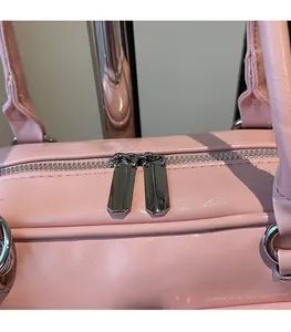 Detail der silbernen Doppelreißverschlüsse und rosa Kunstleder an der Henkeltasche