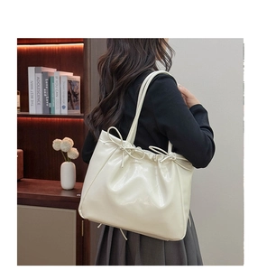 Détail du sac cabas crème avec nœud montrant la texture PU et le cordon de serrage