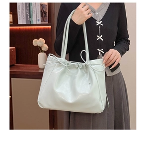 Détail du sac cabas en cuir souple avec plis et nœuds décoratifs au style chic minimaliste