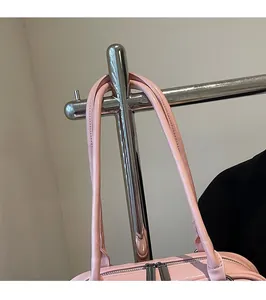 Detailansicht der rosa Ledertasche mit langen Schultergurten und feiner Nahtverarbeitung