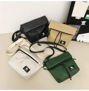Flat lay of nylon crossbody bags in black, khaki, grey, and green with adjustable straps