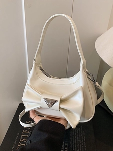 White faux leather crossbody bag with a large bow and silver triangle metal plaque