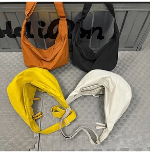 Flat lay of colorful nylon dumpling bags in orange, black, yellow, and off-white