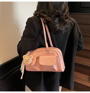 Schultertasche aus rosa Lackleder mit Bärenanhänger und Tuch auf dem Modell
