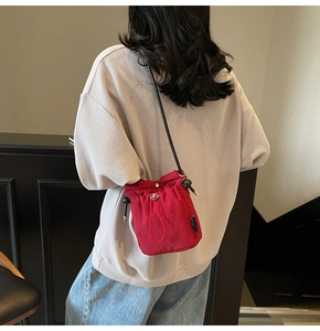 Macro detail of red drawstring bucket bag showing water-resistant nylon and metal hardware