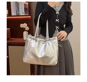 Sac fourre-tout argenté effet miroir avec nœud coulissant porté par un mannequin