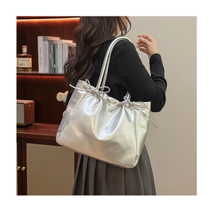Détail du sac cabas argenté métallisé avec nœud coulissant et texture cuir