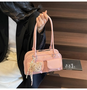Details einer rosa Lackleder-Schultertasche mit Ziertaschen und Plüschbär-Anhänger