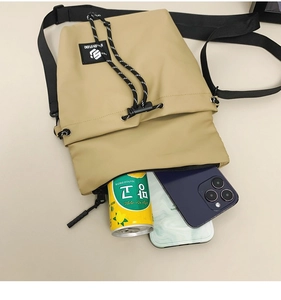 Internal storage detail of khaki nylon crossbody bag with drawstring closure and phone