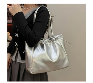 Détail du sac cabas argenté montrant le cordon à nœud et la texture en cuir PU brillant