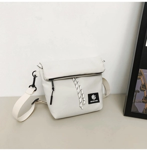 Detail of white nylon crossbody bag with woven cord, logo patch, and adjustable strap