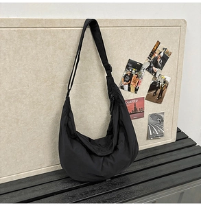 Detail of waterproof nylon hobo bag featuring a wide shoulder strap and sleek zipper closure