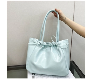 Détail du sac cabas en cuir PU bleu clair avec fini brillant et nœuds décoratifs