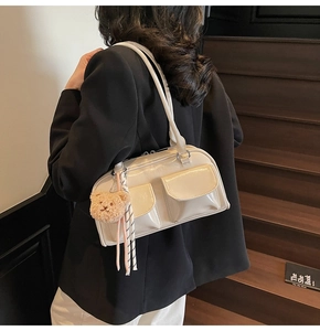 Detail der cremefarbenen Lackleder-Tasche mit Doppeltaschen und Plüschbär-Anhänger