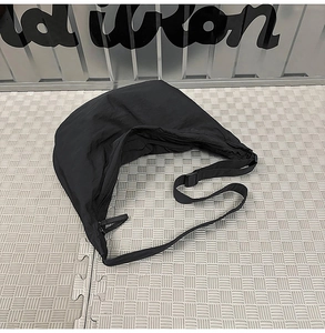 Detail view of the black nylon crescent bag with adjustable strap and plastic buckle