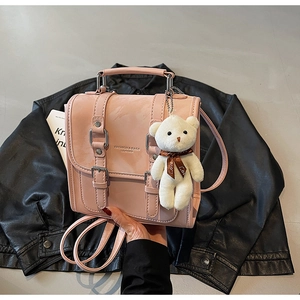 Pink PU leather backpack with double buckle design and cute white teddy bear charm accessory