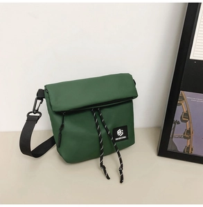 Detail of waterproof nylon crossbody bag with flap, zipper, and adjustable strap