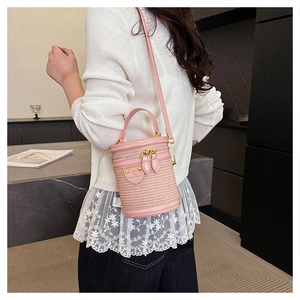 Dettaglio borsa a cilindro rosa intrecciata con logo BLONMAY e doppia zip dorata