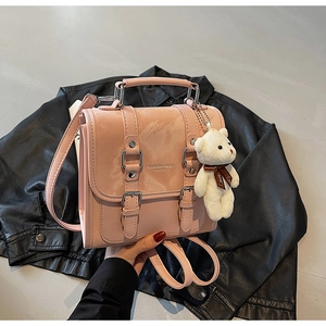 Pink PU leather backpack featuring silver buckles and a cute white teddy bear charm