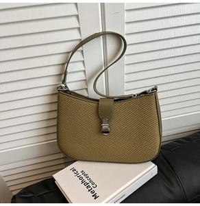 Macro view of olive green shoulder bag showing intricate honeycomb woven texture and clasp