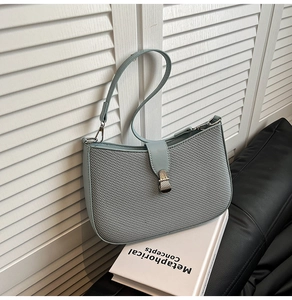 Detail of light blue crossbody bag featuring unique honeycomb fabric texture and silver buckle