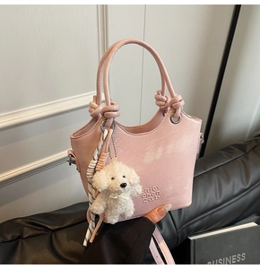 Détail du sac seau rose tendance avec breloque peluche et poignée à nœud élégante