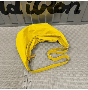 Detail of a bright yellow crescent bag showing the durable nylon texture and adjustable strap
