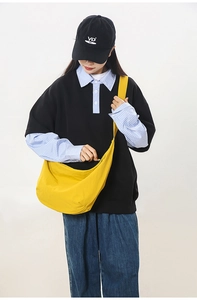 Detailed side view of a vibrant yellow crescent crossbody bag worn by a model