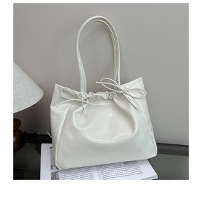 Détail du sac cabas en similicuir crème avec nœuds à cordon et fines bandoulières
