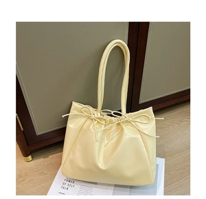 Détail du sac fourre-tout crème avec nœud papillon en similicuir lisse et cordon