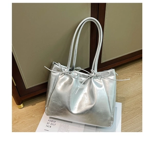 Vue détaillée du nœud argenté métallisé sur ce sac fourre-tout chic et contemporain