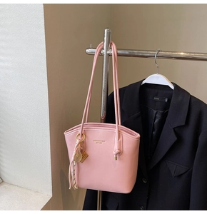 Dettaglio della borsa a secchiello in pelle rosa con ciondolo a racchetta dorato