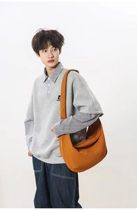 Orange-brown crescent crossbody bag shown on a model in a casual Japanese style outfit