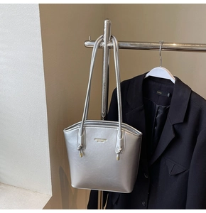 Dettaglio della borsa tote argento metallizzato con scritte dorate su tessuto pregiato