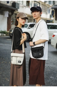 Detail of adjustable nylon straps and woven logo on dual-tone crossbody bags