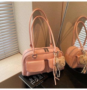 Detailansicht der rosa glänzenden Schultertasche mit zwei Taschen und Plüschbär-Anhänger