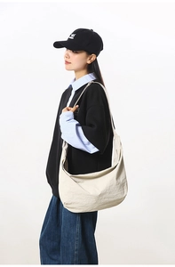 Beige crescent dumpling bag worn by model showing large capacity and soft texture