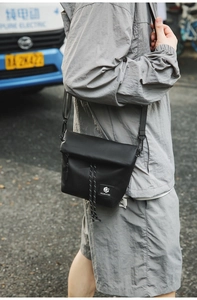 Close-up of minimalist black nylon crossbody bag featuring the Shilaen Studio logo patch