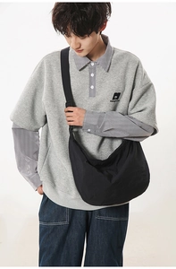 Detailed view of the large black nylon dumpling bag worn with casual Japanese style