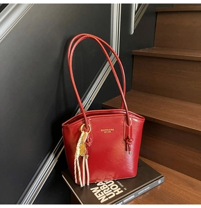 Vista dettagliata della borsa in pelle rossa lucida con nappa intrecciata alla moda