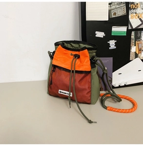 Detail der Nylon-Beuteltasche in Armeegrün mit orangefarbenem Kordelzug und Netztasche
