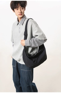 Detailed view of a black nylon crescent bag worn crossbody for a casual streetwear look