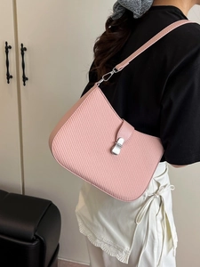 Pink woven texture shoulder bag with silver clasp shown on a model in a minimalist setting