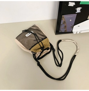 Detailansicht der zweifarbigen Umhängetasche mit schwarzer Netztasche und Seilgurt
