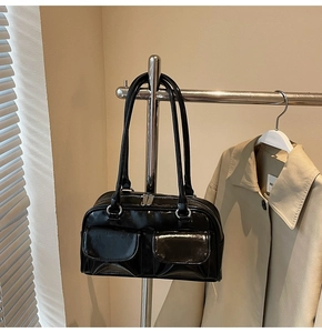 Detailaufnahme einer schwarzen Lackleder-Schultertasche mit silbernen Metallelementen