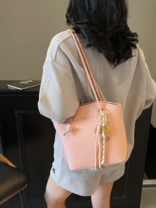 Borsa a spalla rosa in ecopelle con ciondoli dorati e manici superiori da donna
