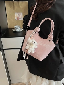 Sac seau rose avec breloque nounours et foulard à carreaux porté en bandoulière