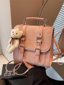 Pink faux leather minimalist backpack with buckle straps and plush bear keychain accessory