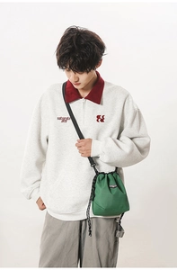 Detail of green checkered drawstring crossbody bag in durable nylon with brand tag
